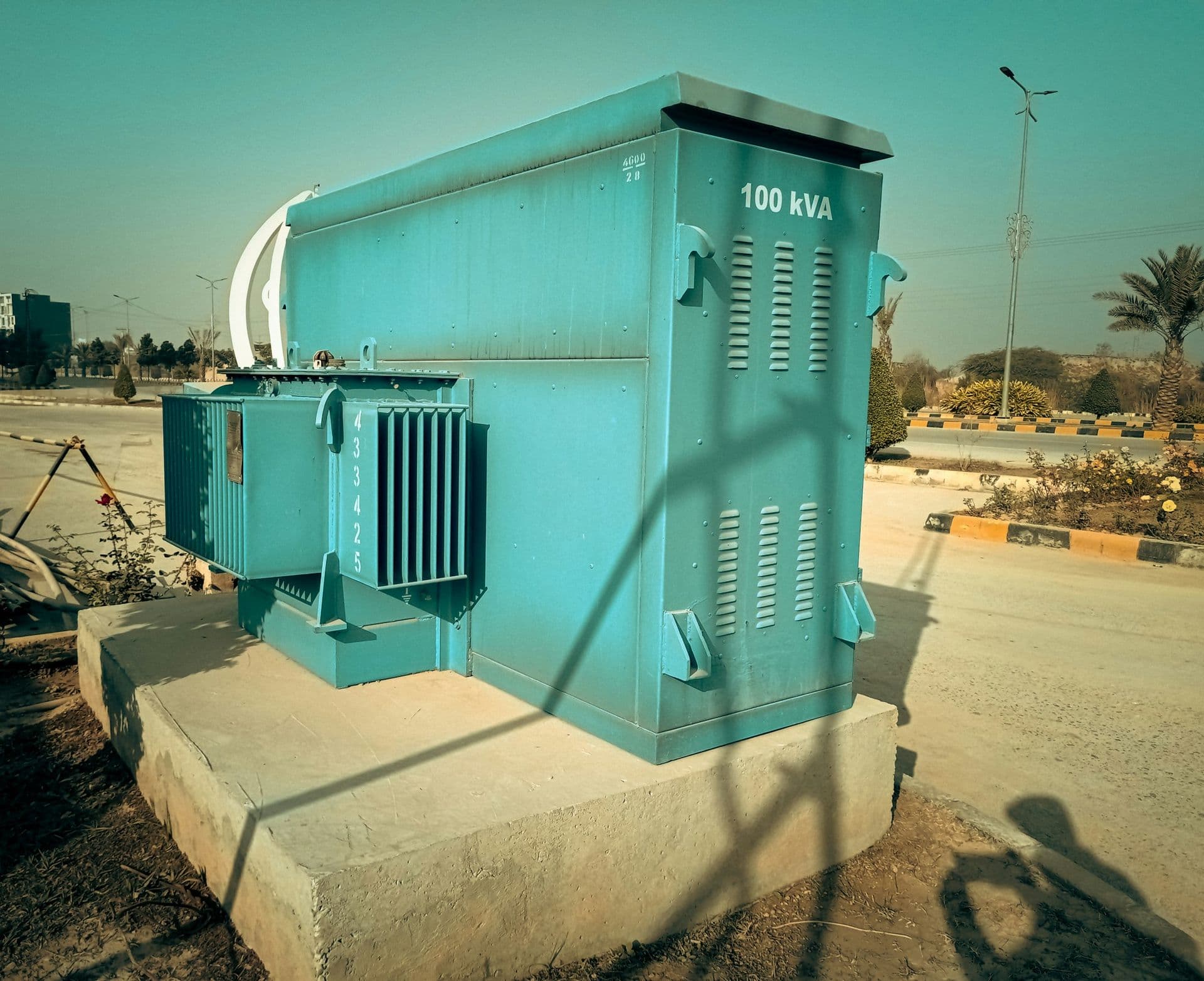 A distribution transformer with its radiator fins, painted green