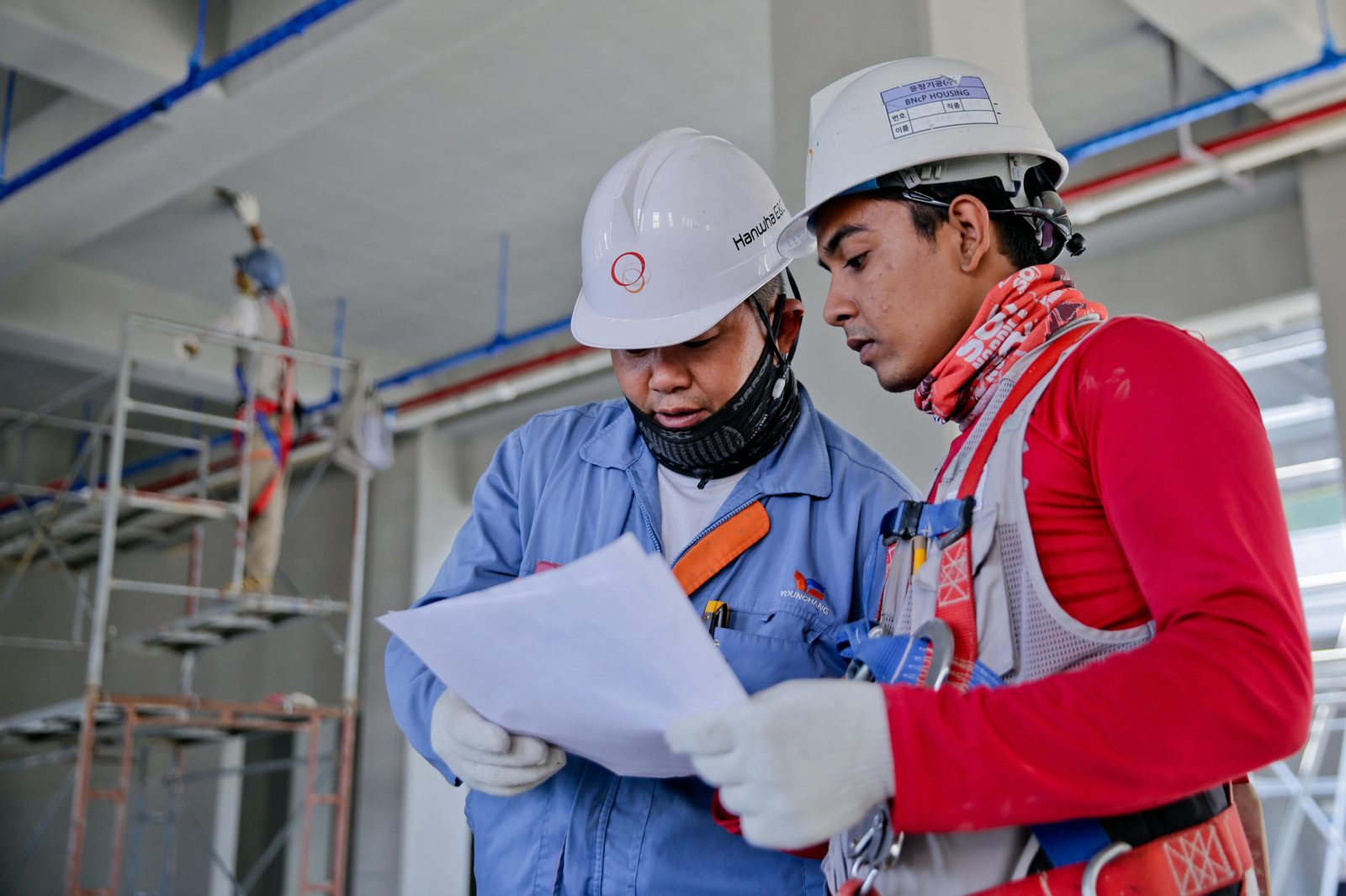 Two field service technicians reviewing plans on a job site