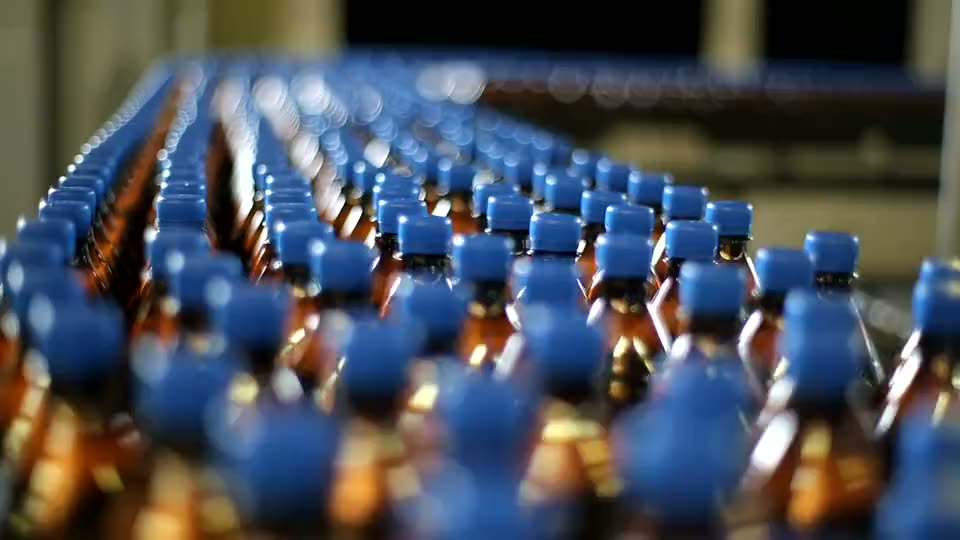 Bottling line moving rows of filled bottles through a plant